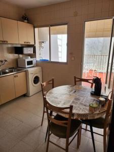 eine Küche mit Tisch und Stühlen und eine Küche mit Mikrowelle in der Unterkunft La Casa de las Golondrinas in Santisteban del Puerto