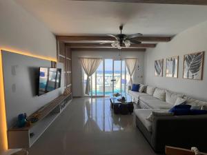 a living room with a couch and a ceiling fan at Spacious 3BR Apartment w Rooftop Terrace Jacuzzi in Ras Elhekma