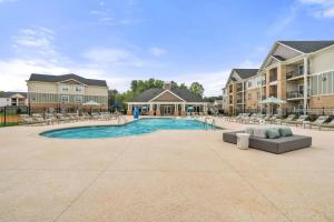 una imagen de una piscina en un complejo con tumbonas en Long-term Stays in Greensboro 1 BD 1 BA, en Greensboro