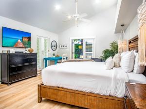 a bedroom with a large bed and a dresser at Palm Suite in Key West