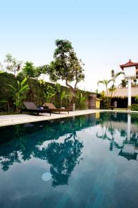 a swimming pool with blue water in a yard at Sasa Bali Villas in Seminyak