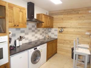 a kitchen with wooden cabinets and a washing machine at Le Chalet Troyen classé 3 étoiles in Troyes