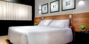 a bedroom with a large white bed in a room at Cambirela Hotel in Florianópolis