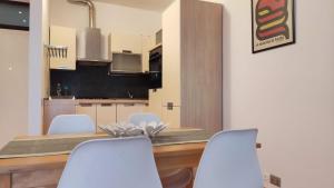 a kitchen with white chairs and a wooden table at A casa di Sara in Recanati