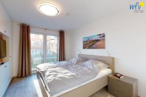a bedroom with a bed and a large window at Haus Seeblick Ferienwohnung Nordseekieker in Wangerooge