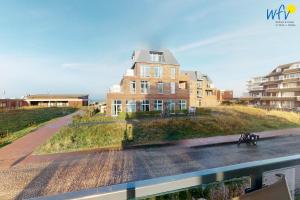 a building on a hill next to a street at Haus Seeblick Ferienwohnung Nordseekieker in Wangerooge
