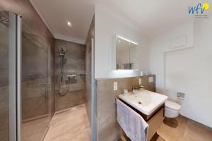 a bathroom with a sink and a shower at Haus Seeblick Ferienwohnung Nordseekieker in Wangerooge +16 photos