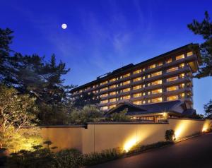 a hotel at night with the moon in the sky at Kamogawakan in Kamogawa
