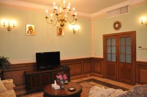 a living room with a chandelier and a tv at Russian Pilgrim Residence in Sowayma