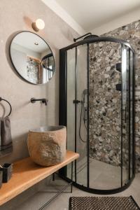 a bathroom with a shower and a bowl on a table at Masarou Suites in Afantou +12 photos