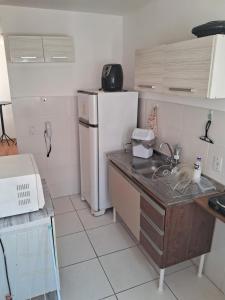 une petite cuisine avec un réfrigérateur et un évier dans l'établissement Apto Oeste simples Santa cruz, à Rio de Janeiro
