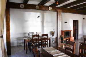 a dining room with a table and chairs and a fireplace at Pensiunea Marceluca in Hodoşa