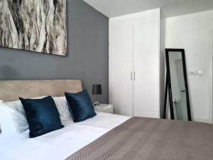 ein Schlafzimmer mit einem großen Bett mit blauen Kissen in der Unterkunft Stylish Apartment near Tower Bridge in London