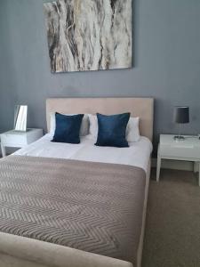 ein Schlafzimmer mit einem großen Bett mit blauen Kissen in der Unterkunft Stylish Apartment near Tower Bridge in London