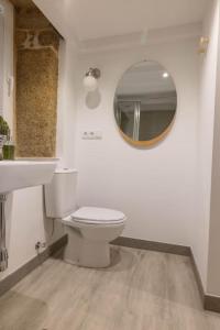 a bathroom with a toilet and a sink and a mirror at Casa Soledá e Pepa in Outes