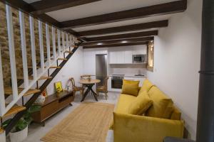 a living room with a yellow couch and a kitchen at Casa Soledá e Pepa in Outes