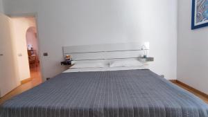 a bedroom with a large bed with a gray blanket at A casa di Sara in Recanati