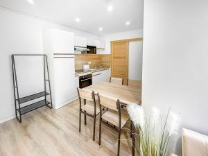 a kitchen and dining room with a wooden table and chairs at Le Toit du Centre-Ville in Romans-sur-Isère +10 photos