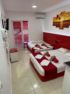 two beds in a room with red and white at Royal Palace in Olympic Beach