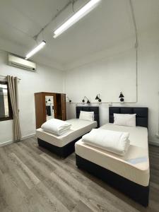 two beds sitting in a room with at Barn1920s Hostel in Vientiane