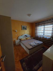 a bedroom with a bed and a window at Apartmani Kolovic Susanj in Bar