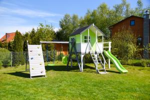 a playground with a slide and a house at Villa HyggeBaltic in Zastań