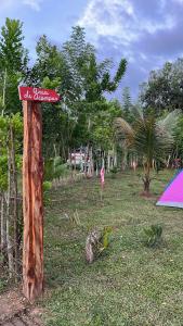 a sign on a pole in a field with a tent at Camping La Bucara in Cabeza de Vaca