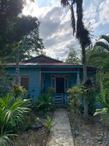 a blue house with a front porch and trees at Camping La Bucara in Cabeza de Vaca