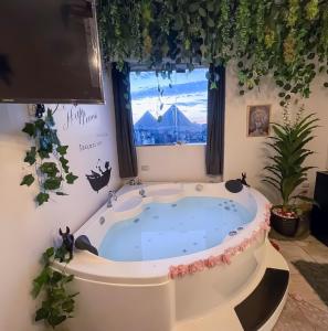 a jacuzzi tub in a room with a window at Pyramids Paradise icon in Cairo