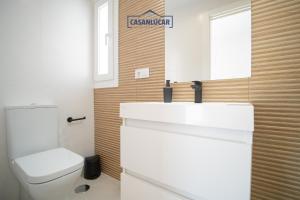 a bathroom with a toilet and a sink and a mirror at Sanlucar Centro - Apartamento 5 in Sanlúcar de Barrameda +20 photos