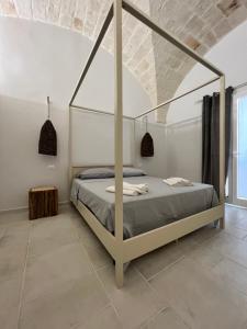 a bedroom with a canopy bed in a white room at Donna Vita in Monopoli