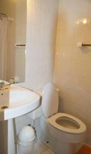 une salle de bain blanche avec toilettes et lavabo dans l'établissement Depto frente a la playa en Av del Mar con piscina Se permiten mascotas Mac04, à La Serena