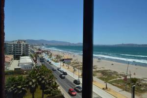 une vue de la plage depuis la fenêtre d'un hôtel dans l'établissement Depto frente a la playa en Av del Mar con piscina Se permiten mascotas Mac04, à La Serena