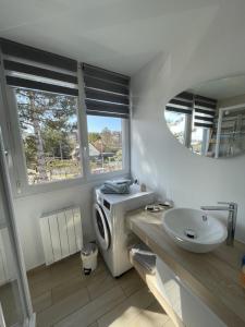 a bathroom with a sink and a washing machine at Le Loft de Flore in Dieppe +1 photo