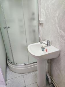 a bathroom with a sink and a shower at Saidjanov Hostel in Bukhara
