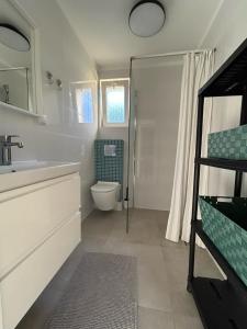 łazienka z toaletą, umywalką i prysznicem w obiekcie Villa LILIA w mieście Międzywodzie +14 zdjęć