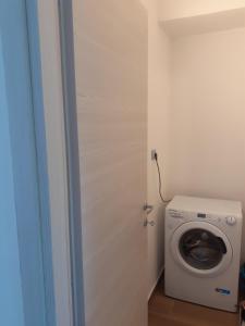 a bathroom with a washing machine in a room at La tenuta Moscatella a 200m dal mare in Schisò