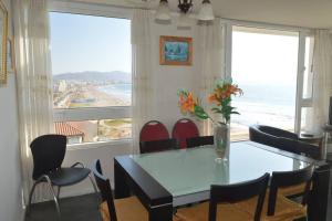 a dining room table and chairs with a view of the ocean at Depto frente al mar con wifi Se permiten mascotas Mac06 in La Serena