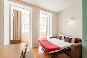 a bedroom with a bed with a red blanket at VIVA Three Magi Residence in Porto