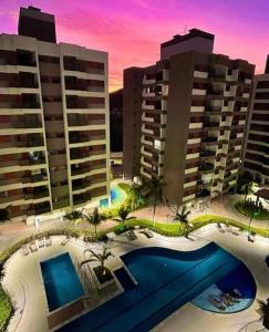 Blick auf ein Resort mit Pool und Gebäuden in der Unterkunft Luxuoso AP no Martim Praia Clube - Martim de Sá in Caraguatatuba