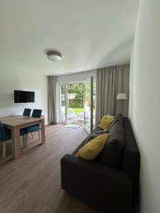 salon z kanapą, stołem i biurkiem w obiekcie Villa LILIA w mieście Międzywodzie