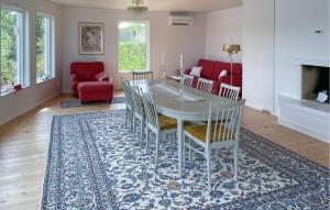 a dining room with a table and chairs on a rug at Stunning Home In Färgelanda in Färgelanda