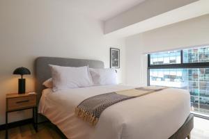 a bedroom with a large white bed with a window at Living 110 Suites by Wynwood House in Lima