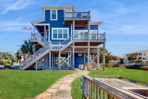 a blue house with stairs on the side of it at All Rise (Private Boat Dock) in Holden Beach