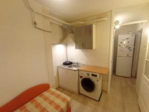a small kitchen with a sink and a washing machine at A comfortable room with balcony in Tallinn +14 photos