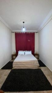 a bedroom with a large bed with a red curtain at Dar Fouzia in Kasba Aït Youdi