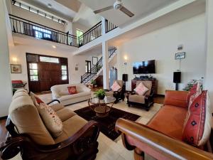 a large living room with couches and a tv at MYH - Lake Front Pvt Villa with Staff and Includes FREE Breakfast of your choice in Bandaragama