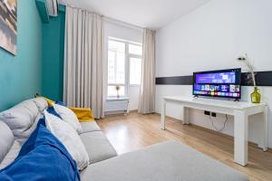 a living room with a couch and a table with a tv at Apartment near EXPO-2017, Hilton in Taldykolʼ