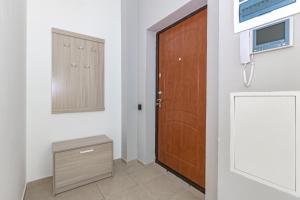 a room with a door and a tv and a cabinet at Apartment near EXPO-2017, Hilton in Taldykolʼ