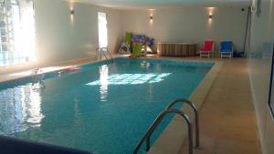 a large swimming pool in a large room with chairs at Château De Saint-Maixant in Saint-Maixant